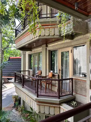 a house with a balcony with a table and chairs at Galayanee’s Resort Apartment in Seminyak