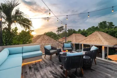 a patio with a blue couch and chairs on a deck at Villa Mahkota Seminyak in Seminyak