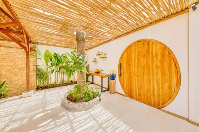 a room with a wooden door and a table and plants at Villa Miami - New Luxury 7BDR Prime Location in Seminyak