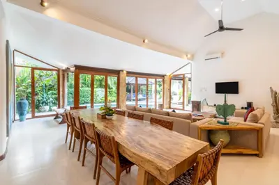 a dining room with a large wooden table and chairs at Enclose living 5Br Villa Center of Seminyak Near Beach in Seminyak