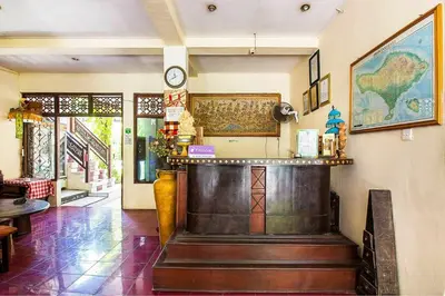 a bar in a restaurant with a clock on the wall at SANJAYA HOTEL in Legian