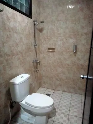 a bathroom with a toilet and a shower at SANJAYA HOTEL in Legian