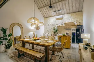 a dining room with a wooden table and chairs at Villa Aarka - Chic Balinese Bohemian Retreat in Seminyak in Seminyak
