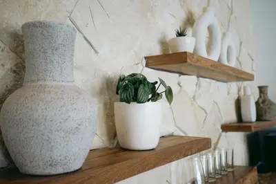 a couple of white vases sitting on a wooden shelf at Villa Aarka - Chic Balinese Bohemian Retreat in Seminyak in Seminyak