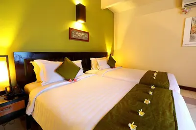 two beds in a room with green walls at The Bali Bliss Villa in Seminyak