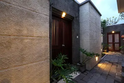 a brick building with a red door and a courtyard at The Bali Bliss Villa in Seminyak