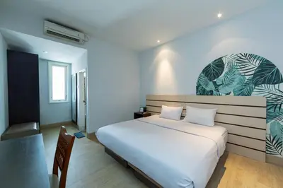 a bedroom with a large white bed in a room at Cove Matahari Senja in Denpasar