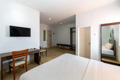 a bedroom with a bed and a desk and a bed at Cove Matahari Senja in Denpasar