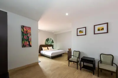 a bedroom with a bed and a table and chairs at Cove Matahari Senja in Denpasar