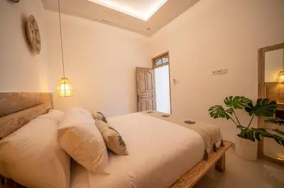 a bedroom with a bed and a potted plant at Villa James Seminyak in Seminyak