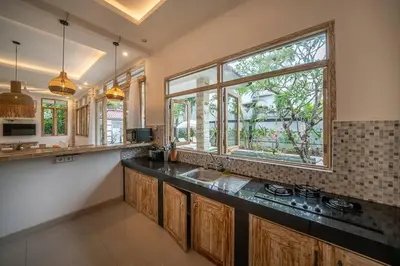 a kitchen with a sink and a large window at Villa James Seminyak in Seminyak