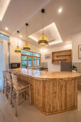 a large kitchen with a large wooden island in a room at Villa James Seminyak in Seminyak