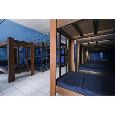 a room with three bunk beds and a blue wall at Bunk Bed Bali near Sanur Mitra RedDoorz in Pesanggaran