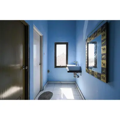 a bathroom with a sink and a blue wall at Bunk Bed Bali near Sanur Mitra RedDoorz in Pesanggaran