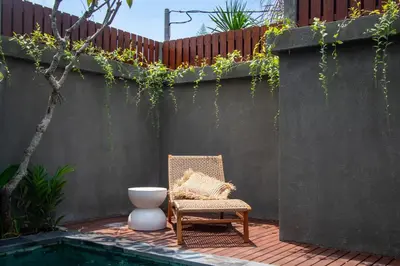 a chair and a vase sitting next to a fence at Sundaze 2 - Canggu Paradise with Pool and Kitchen Brand NEW in Kerobokan