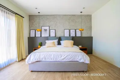 a bedroom with a large bed with two pillows at Villa Palm Suites Bali in Seminyak