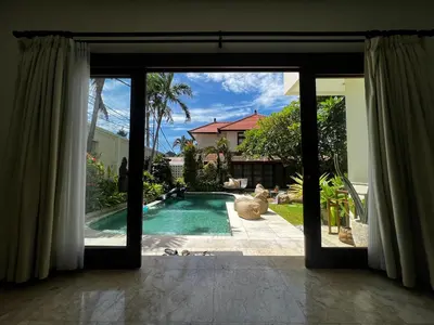 a view of a swimming pool through a sliding glass door at Villa Palm Suites Bali in Seminyak
