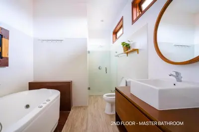 a bathroom with a tub and a sink and a mirror at Villa Palm Suites Bali in Seminyak
