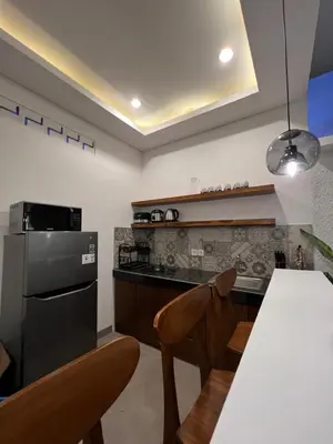 a kitchen with a black refrigerator and a table at Villa Carik by Globalstay - Kerobokan x Seminyak x Canggu in Kerobokan