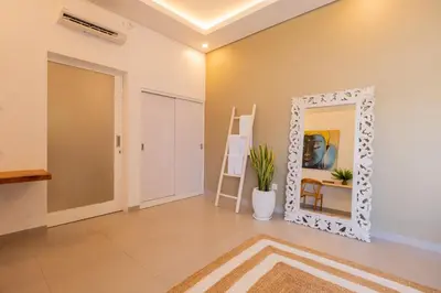 a mirror in a room with a table and a chair at Casa Moana Seminyak 3BR Stylish Private Pool Villa in Seminyak