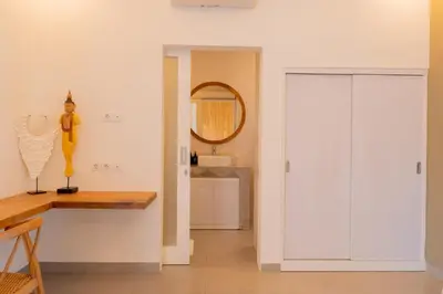 a bathroom with a white closet and a mirror at Casa Moana Seminyak 3BR Stylish Private Pool Villa in Seminyak