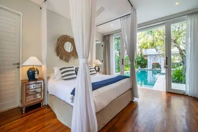 a bedroom with a canopy bed and a swimming pool at Villa Sunsara 2 - Spacious 4-Bedroom Haven next to Berawa Beach in Canggu
