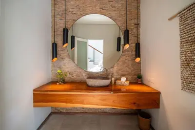 a bathroom with a wooden counter with a mirror at Villa Sunsara 2 - Spacious 4-Bedroom Haven next to Berawa Beach in Canggu
