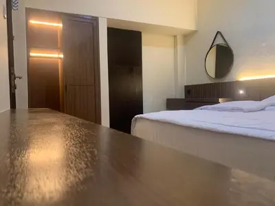 a bedroom with a bed and a mirror on the wall at Cahaya Residence The Guest House in Kuta