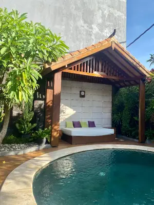 a pergola and a swimming pool in a backyard at Meilds Property Segara Kuta in Kuta