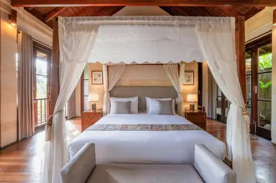 a bedroom with a white bed with a canopy at Villa Pulung Jimbaran by Nakula in Jimbaran