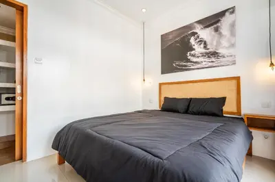 a bedroom with a bed and a picture on the wall at Lumturi House - Centrally Located in Seminyak