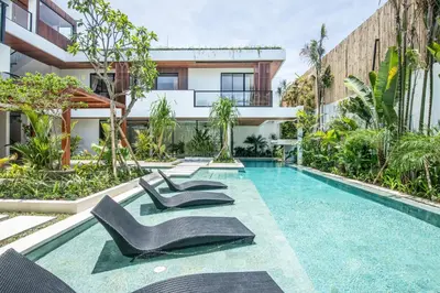 an image of a swimming pool with chairs in front of a building at Brand new Luxury 5 br villa 200m to Brawah Beach in Canggu