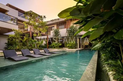 a swimming pool with lounge chairs in front of a building at Brand new Luxury 5 br villa 200m to Brawah Beach in Canggu