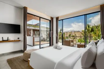 a bedroom with a large white bed and a tv at Brand new Luxury 5 br villa 200m to Brawah Beach in Canggu