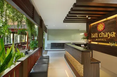 a restaurant with a bar with chairs and plants at Bali Chaya Hotel Legian in Legian