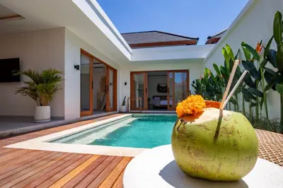 a coconut sitting on a table next to a swimming pool at Balibay 1 - Private Villa with Pool in Canggu in Kerobokan