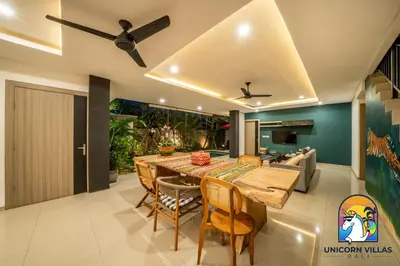 a dining room with a large wooden table and chairs at Rumah Senang - by Unicorn Villas Bali in Seminyak