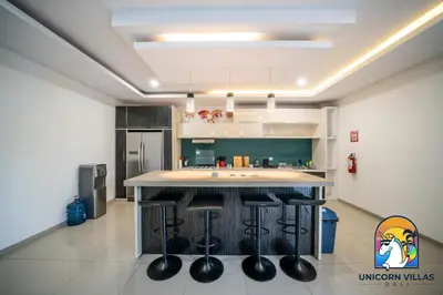 a kitchen with a island with bar stools at Rumah Senang - by Unicorn Villas Bali in Seminyak