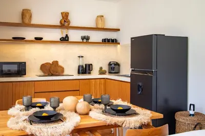 a kitchen with a wooden table and a refrigerator at Balibay 2 - Best Place by the Beach in Canggu in Kerobokan