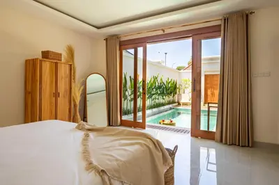 a bedroom with a bed and a view of a pool at Balibay 2 - Best Place by the Beach in Canggu in Kerobokan