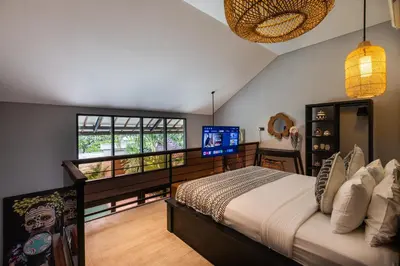 a bedroom with a bed and a television in it at Villa Zazu in Seminyak