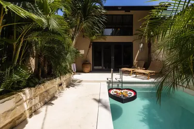 a house with a pool with a bowl of food in it at Villa Zazu in Seminyak