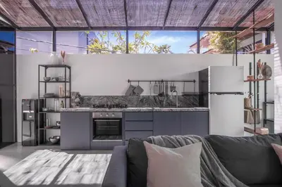 a living room with a couch and a kitchen at Sasa's Villa Seminyak in Seminyak