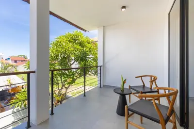a room with a balcony with a table and chairs at Sasa's Villa Seminyak in Seminyak