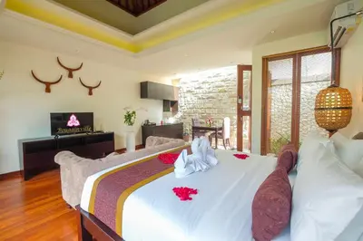 a bedroom with a large white bed with flowers on it at Villa Bougainville in Seminyak
