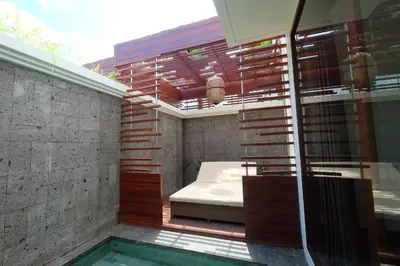 a bedroom with a bed and a swimming pool at Villa Bougainville in Seminyak