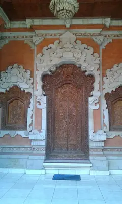 a large wooden door on the side of a building at Ratih Bali Hostel in Denpasar