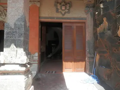 an entrance to a building with a wooden door at Ratih Bali Hostel in Denpasar