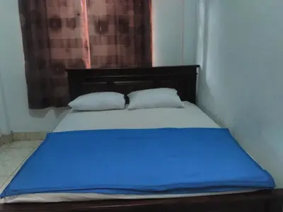 a bed with blue sheets and pillows in a room at Ratih Bali Hostel in Denpasar