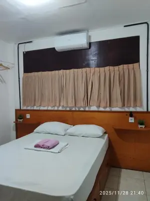 a white bed with a window with a pink phone on it at Rodin Bali Hostel in Seminyak